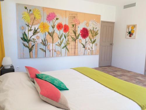 een slaapkamer met een bed met een schilderij aan de muur bij Les Toiles du 15 in Montaren-et-Saint-Médiers