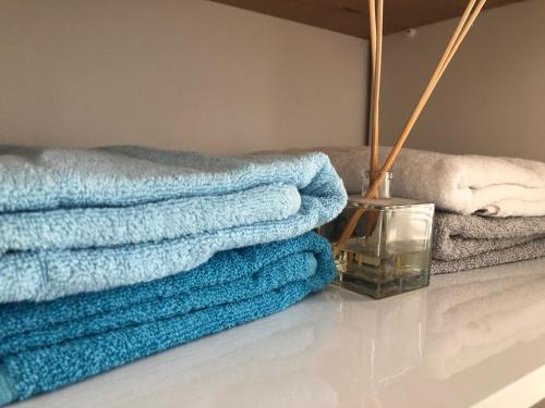 a pile of towels sitting on a floor next to a couch at Sea You Soon! in Netanya