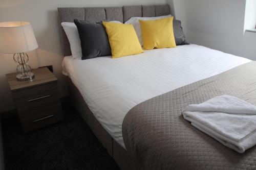 a bedroom with a bed with yellow pillows and a lamp at Halifax House, Studio Apartment 213 in Halifax