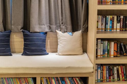 a bench in a book shelf with pillows at Amaka Bed and Breakfast in Chiang Mai