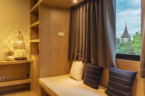 a bed in a room with a window at Amaka Bed and Breakfast in Chiang Mai