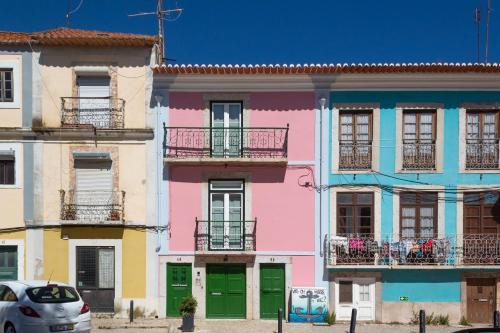 a row of colorful houses with a car parked in front at Hooked on Troino in Setúbal
