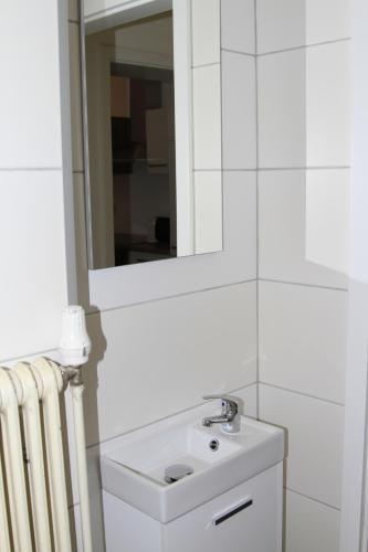 a white bathroom with a sink and a mirror at Apartment Fonhauser in Amstetten