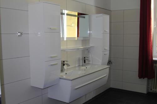 een witte badkamer met een wastafel en een spiegel bij Apartment Fonhauser in Amstetten