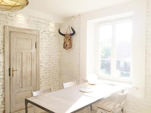 a white dining room with a table and chairs at WHITE HOUSE - silesian loft apartment in Dąbrowa Górnicza
