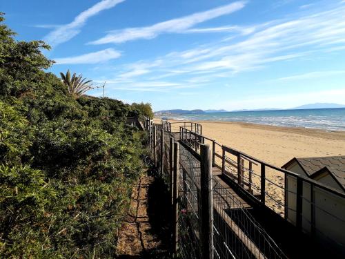 a sandy beach with a fence and the ocean at Villa Biagi in San Vincenzo