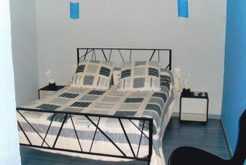1 dormitorio con cama con marco negro y almohadas en chambre d'hotes a nérac, en Nérac