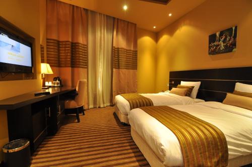 Een bed of bedden in een kamer bij Aldar Hotel
