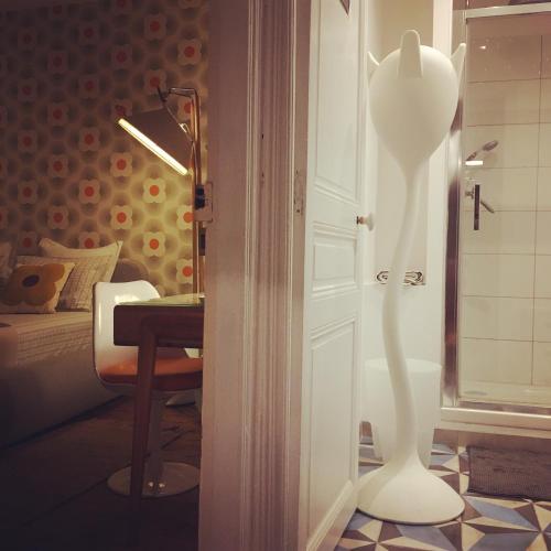 a room with a white cat standing next to a door at Chez Ric et Fer in Coucy-le-Château-Auffrique