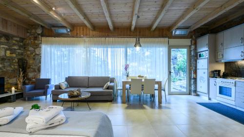 ein Wohnzimmer mit einem Sofa und einem Tisch in der Unterkunft Amicasa Private Seaside Suite in Pachi