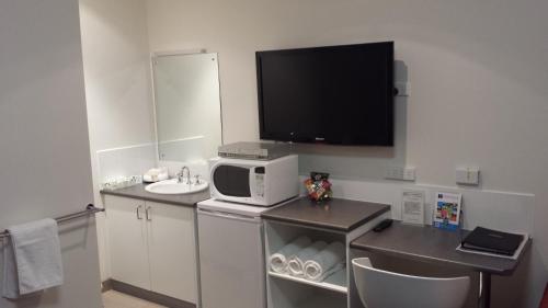a small bathroom with a sink and a microwave at McLaren Vale Motel & Apartments in McLaren Vale