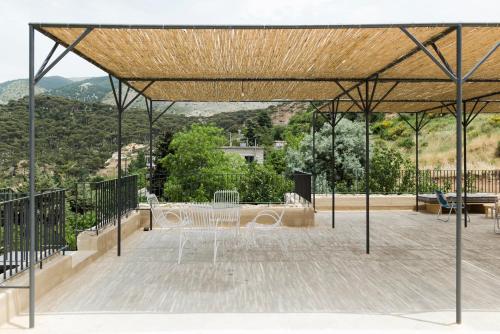 a pavilion with a table and chairs on a deck at La Maison des Sources in ‘Ayn Zḩaltā