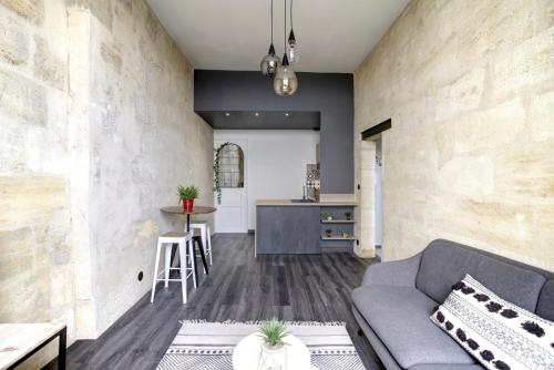 un salon avec un canapé et une cuisine dans l'établissement Le Port de la Lune - Vue panoramique sur les Quais, à Bordeaux