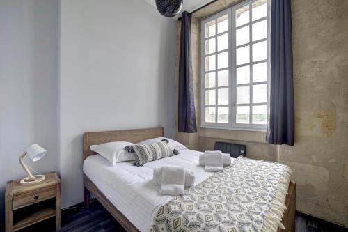 Ce lit se trouve dans un dortoir doté d'une fenêtre et d'un lit sidx sidx. dans l'établissement Le Port de la Lune - Vue panoramique sur les Quais, à Bordeaux