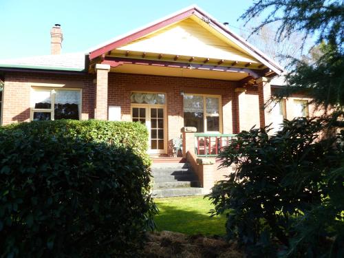 a small brick house with a porch and a yard at Donalea Bed and Breakfast & Riverview Apartment in Castle Forbes Bay