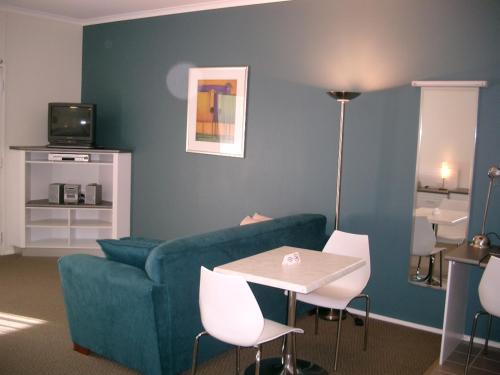a living room with a couch and a table and chairs at McLaren Vale Motel & Apartments in McLaren Vale