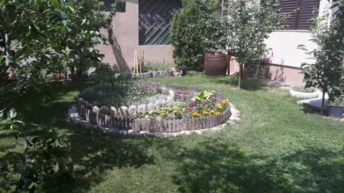 a garden with a flower bed in the grass at Villa Domina in Gevgelija