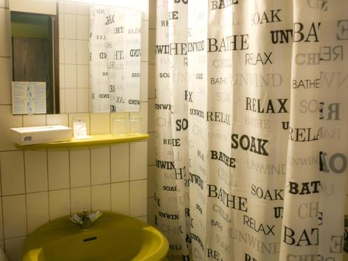 a bathroom with a shower curtain and a green sink at Hotel Oronto in Koblenz