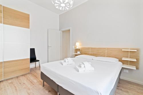 ein Schlafzimmer mit einem großen weißen Bett und einem Stuhl in der Unterkunft Prato della Valle Central Apartment in Padua