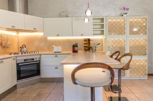 a kitchen with white cabinets and a counter top at Villa La Perla - Bellagio in Bellagio