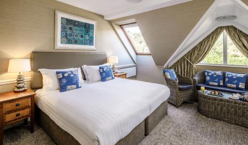 a bedroom with a bed and a chair in a room at Golden Sands in St Brelade