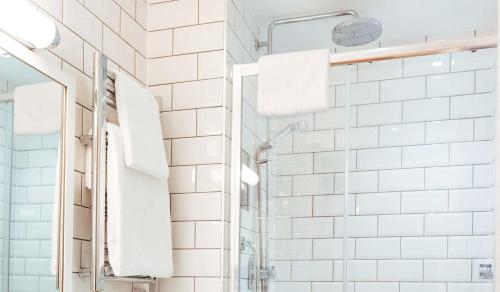 a bathroom with white subway tiles and a shower at Golden Sands in St Brelade