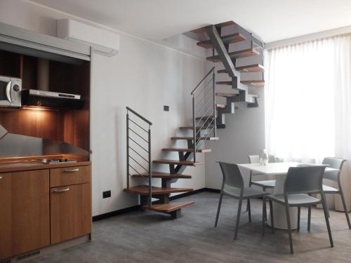 a kitchen and dining room with a spiral staircase at Hotel Carlton in Ferrara