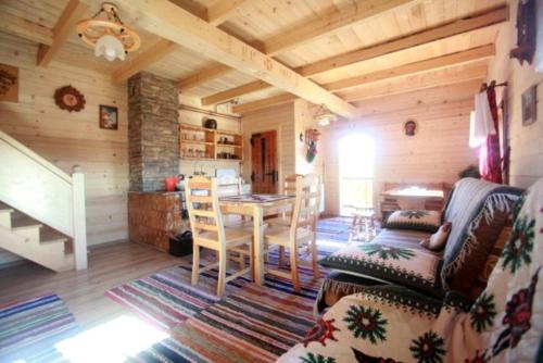 een woonkamer met een tafel en stoelen in een hut bij Domek na uboczu in Klikuszowa