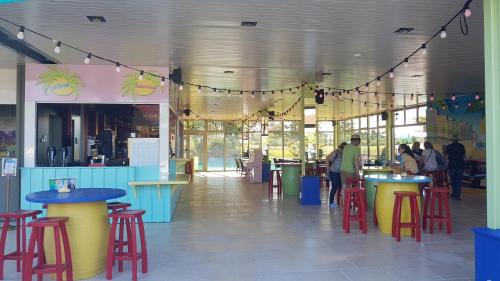 un restaurant avec des tables et des tabourets colorés dans un bâtiment dans l'établissement floryll, à Fumel