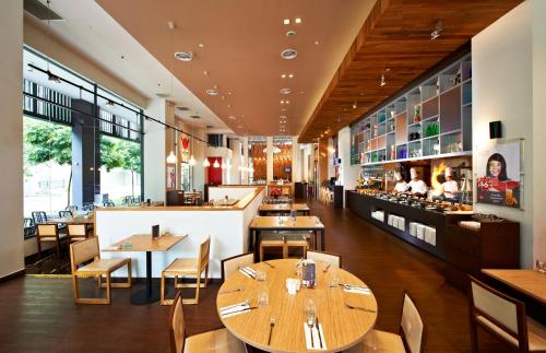 新加坡新加坡宜必思诺维娜酒店的有木桌椅和酒吧的餐厅