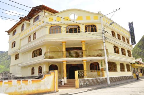 a large yellow building on the side of a street at Hotel Donde Marcelo in Baños