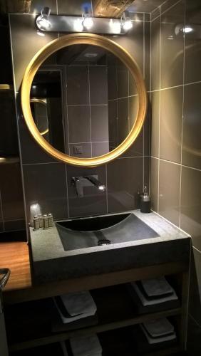 a bathroom with a sink and a mirror at Les Chalets de Maramour in Chazey-sur-Ain