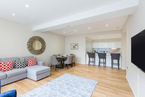 a living room with a couch and a table at Urban Chic - Exeter Street in London