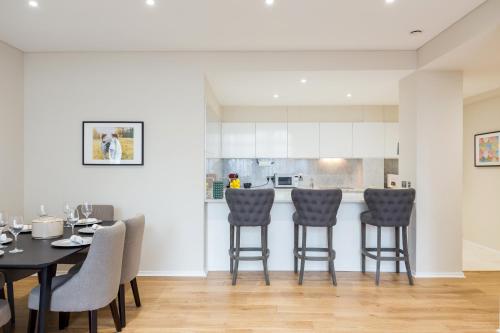 a kitchen and dining room with a table and chairs at Urban Chic - Exeter Street in London