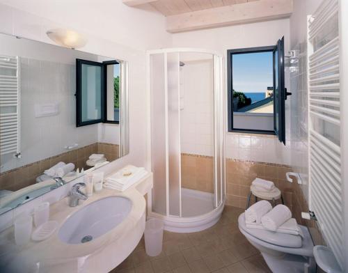 uma casa de banho com um lavatório, um WC e um chuveiro em Residence Ascot em Cattolica