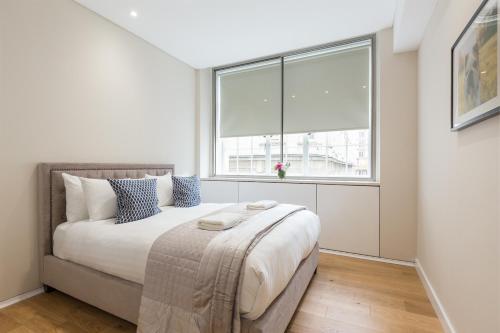 a bedroom with a bed with a large window at Urban Chic - Exeter Street in London