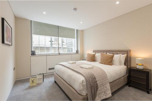 a bedroom with a large bed and a window at Urban Chic - Exeter Street in London