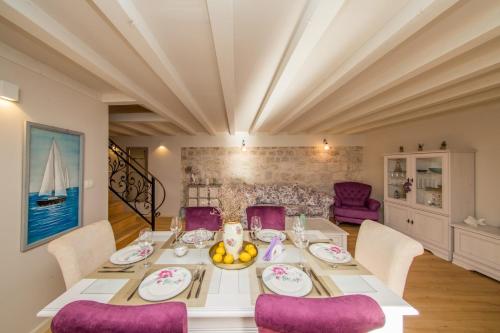 a dining room with a table and purple chairs at Villa Martina in Komiža