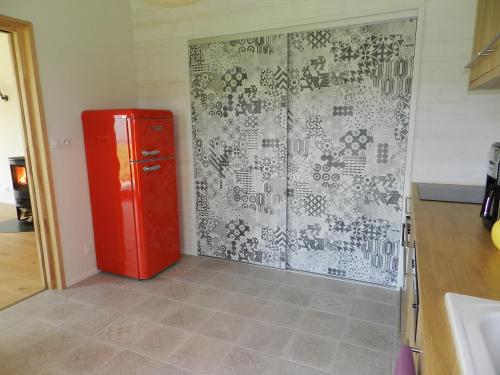 a kitchen with a red refrigerator in a room at Le Koto in Thorigny