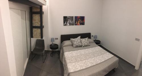 1 dormitorio con 1 cama y una foto en la pared en La Guarida del Fraile, en Granada