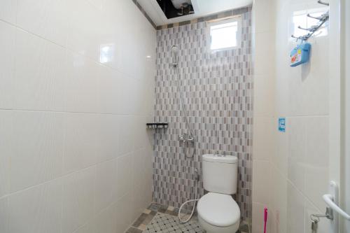 a small bathroom with a toilet and a shower at RedDoorz Syariah @ Panglima Polem Aceh in Banda Aceh