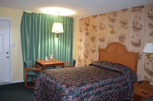 Habitación de hotel con cama, escritorio y sidra de mesa en Paramount Motel Pocono, en East Stroudsburg