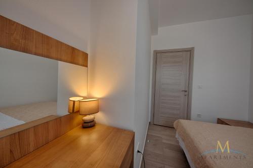 a bedroom with a bed and a table with a lamp at M Apartments in Bar