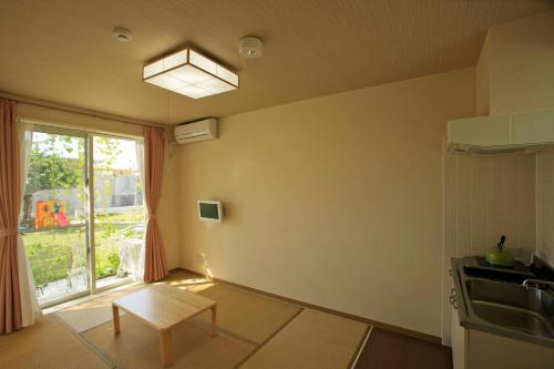 a small kitchen with a table and a window at Cha Villa in Zamami