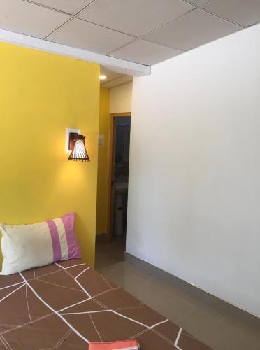 a room with a yellow wall and a couch at Villa Eco Green Airport in Katunayake