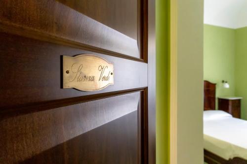 a bedroom with a wooden door with a sign on it at Dimora La Torre Room in Favignana