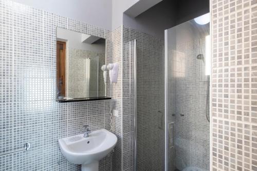 a bathroom with a sink, mirror, and shower stall at Dimora La Torre Room in Favignana