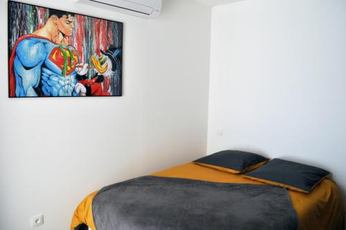 a bedroom with a bed with a painting on the wall at Ibanova Appartements in Collioure