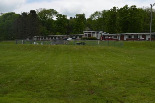 a field of green grass with buildings in the background at Paramount Motel Pocono in East Stroudsburg