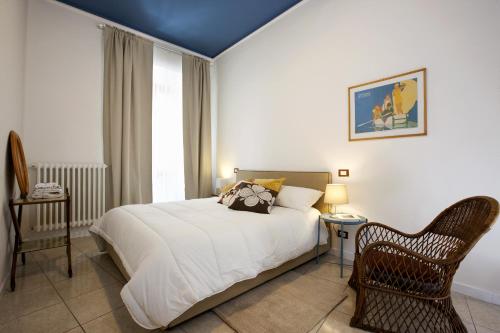 een slaapkamer met een bed, een stoel en een raam bij CARLETTI URBAN FLAT in Viterbo